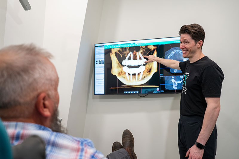 Doctor going over dental implant x-ray with patient