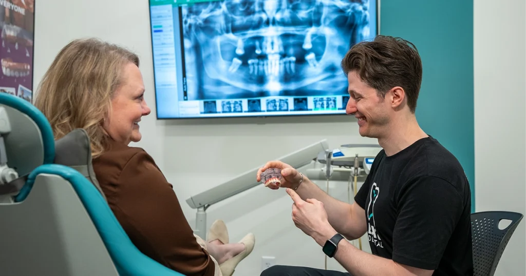 Patient smiling with new fixed teeth on the day of their same-day dental implants