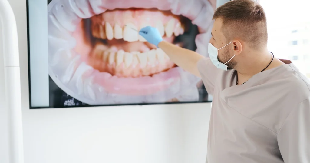 Dentist explaining a dental bone graft to a patient using a jaw model