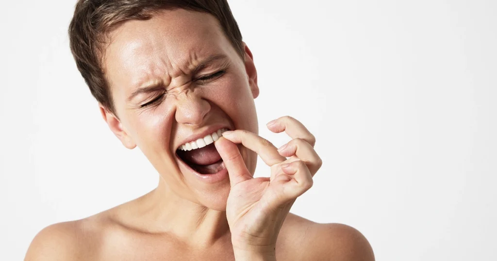 Person holding a knocked-out tooth carefully by the white crown, not the root