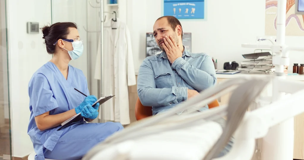 dentist explains to a patient what counts as a dental emergency