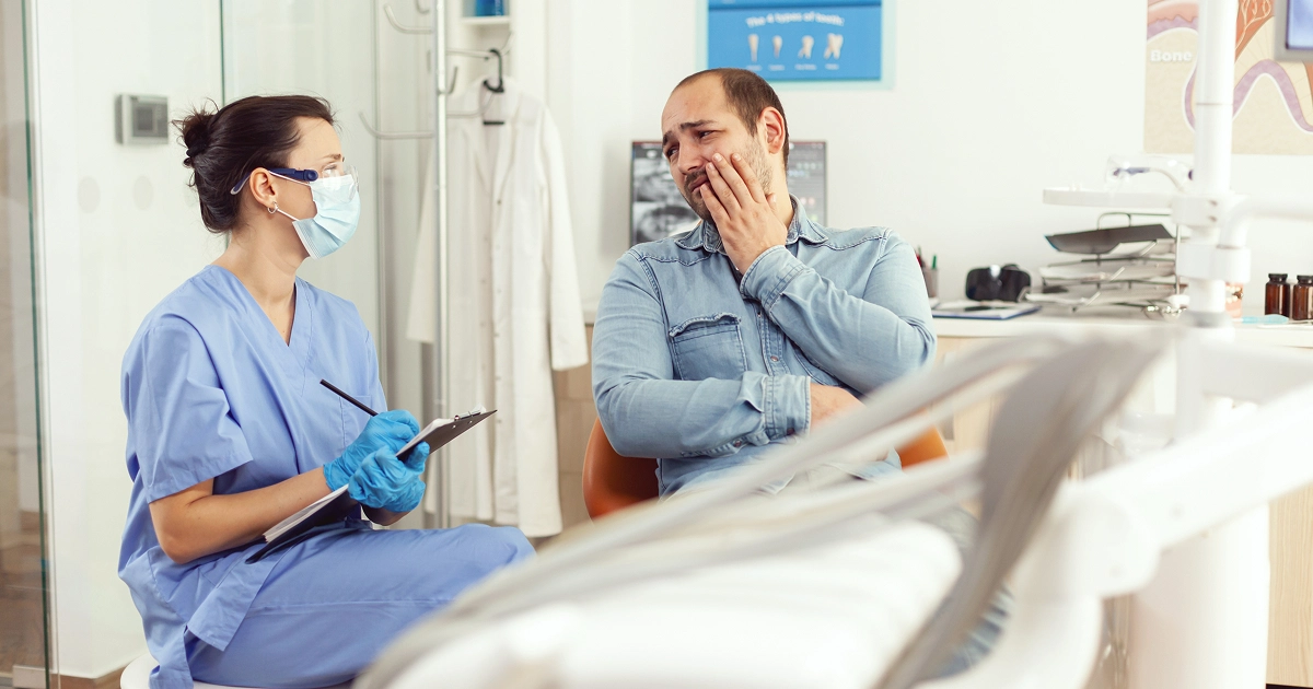 dentist explains to a patient what counts as a dental emergency
